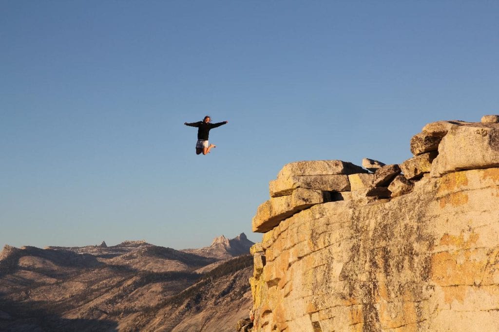 Training your inner caveman to take risks: man jumping off cliff