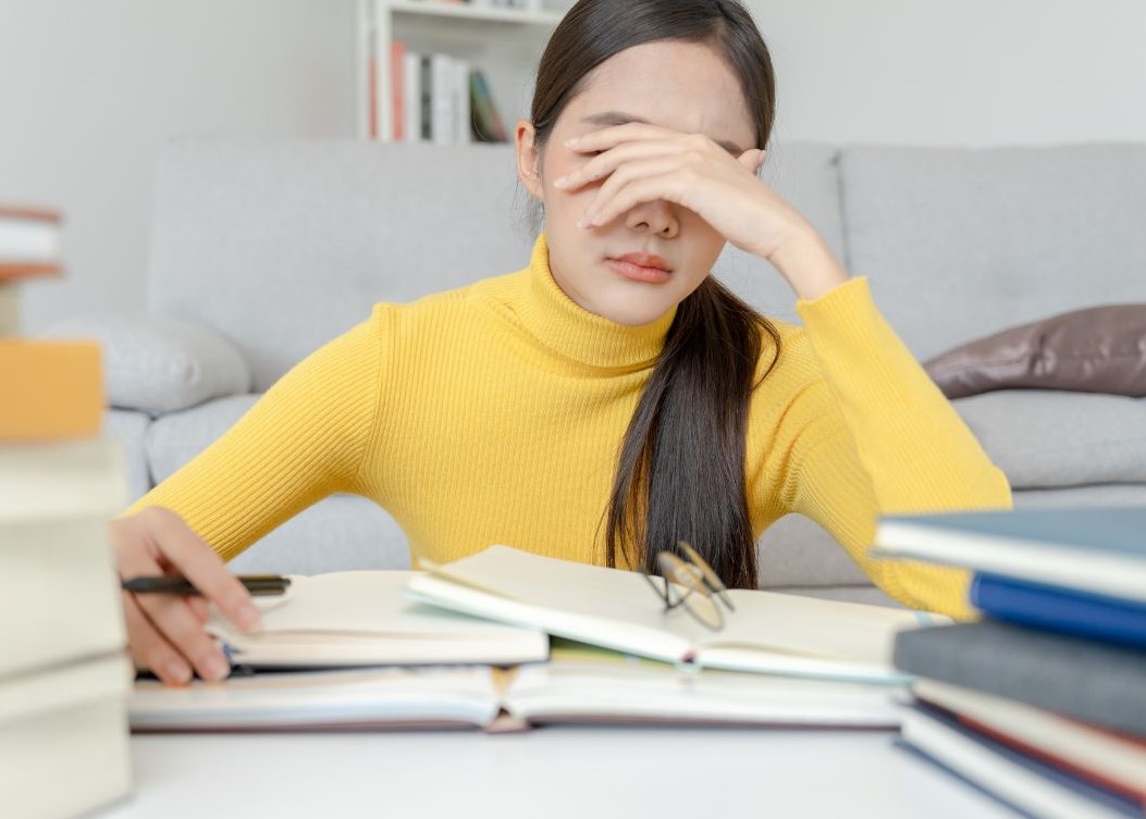 Frustrated student with a pile of books