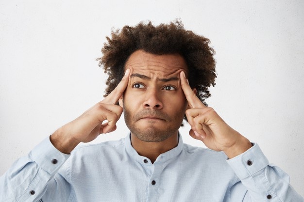 Student pausing mid-revision, struggling to recall what he has just read